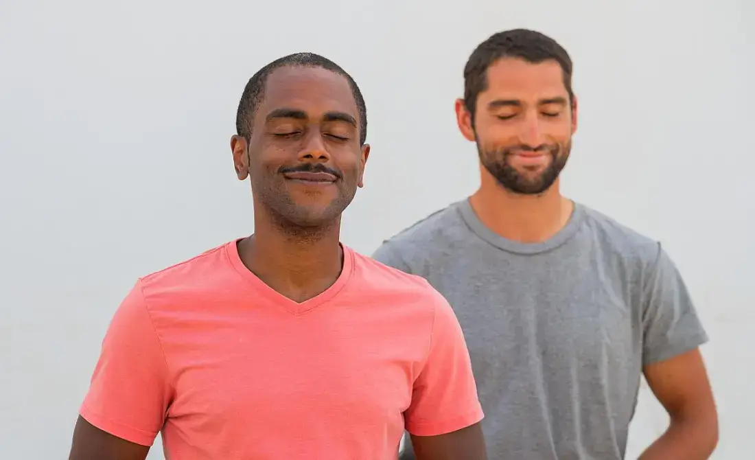 two men engaged in peaceful meditation with their eyes closed