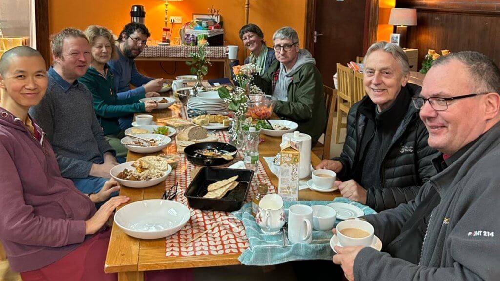 people enjoying a vegetarian meal all sat around a table