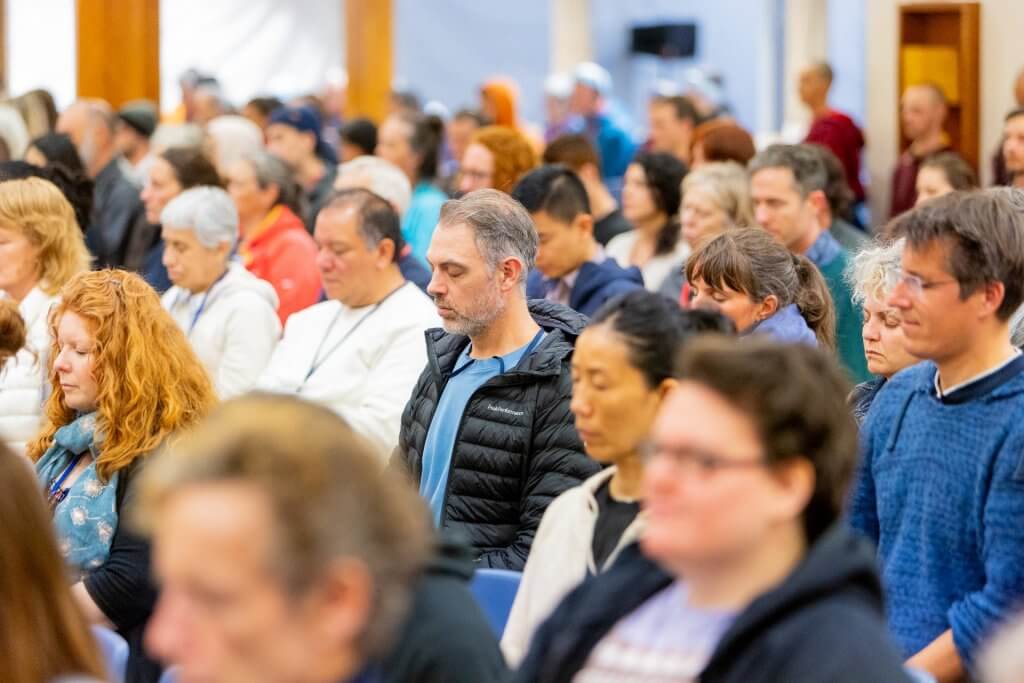 crowd of people meditating in buddhis temple
