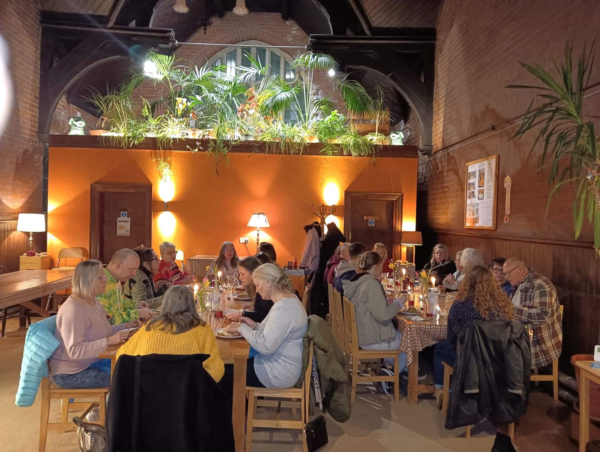 A group of people enjoying a meal and chatting to each other at Vajrapani Kadampa Meditation centre