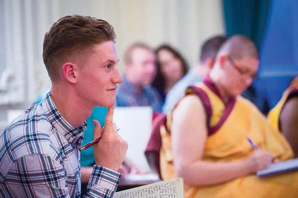 A man looking very thoughtful whilst listening to a Buddhist class