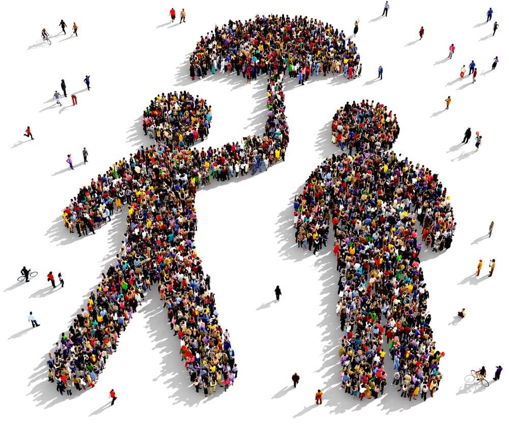 A crowd of people forming an image of someone holding an umbrella to protect someone else, as seen from above.